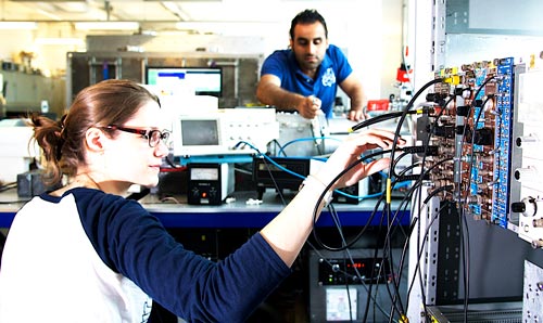Woman plugging wires into equipment